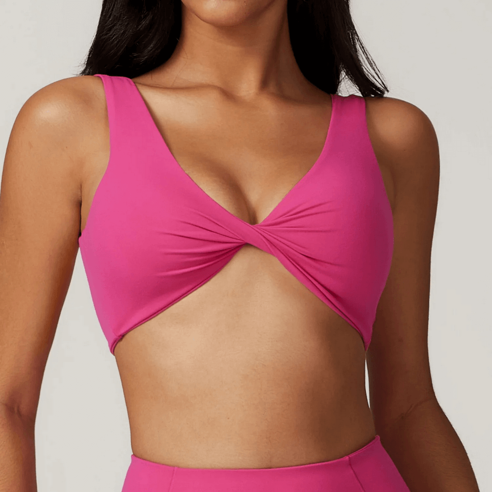 Pink twist front sports bra top for fitness and yoga, designed for high support and style, perfect for workouts and dancing.