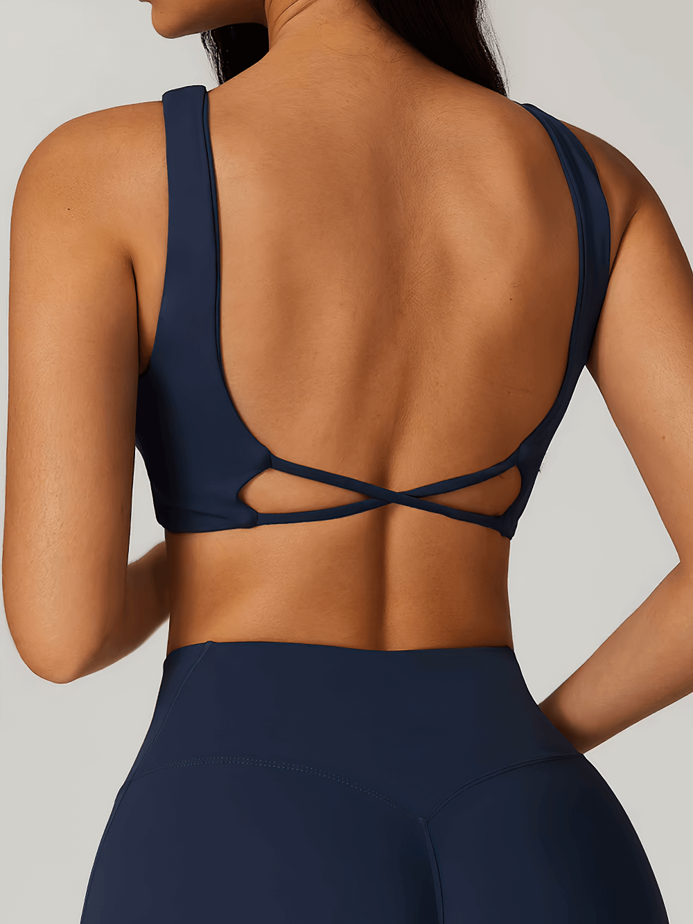 Back view of twist-front backless sports bra in navy blue, perfect for fitness and yoga. Made from breathable, quick-dry fabric for workouts.