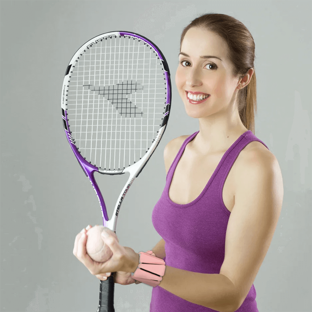 Woman in purple top holding a tennis racket, wearing a two-color fitness bracelet weight on her wrist for training.