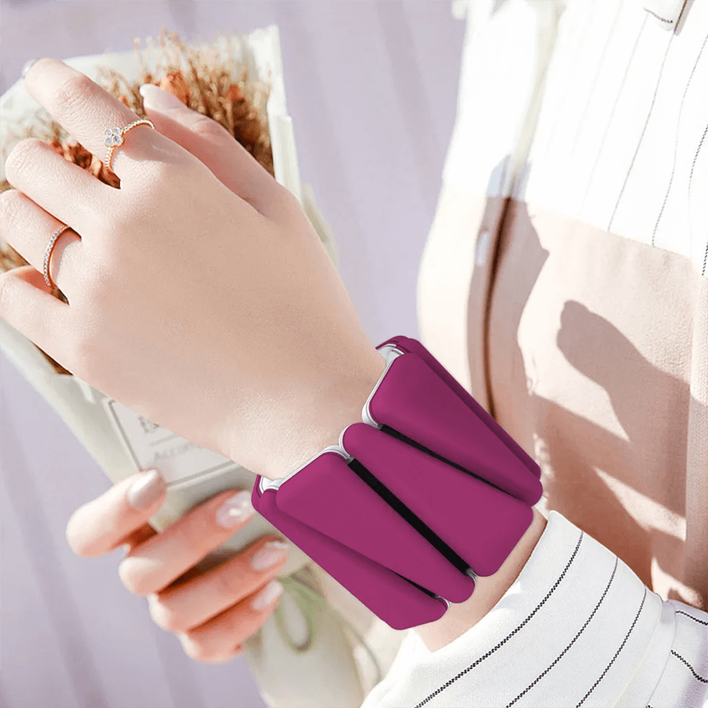 Person wearing purple weighted silicone bracelet for fitness training, shown on wrist.