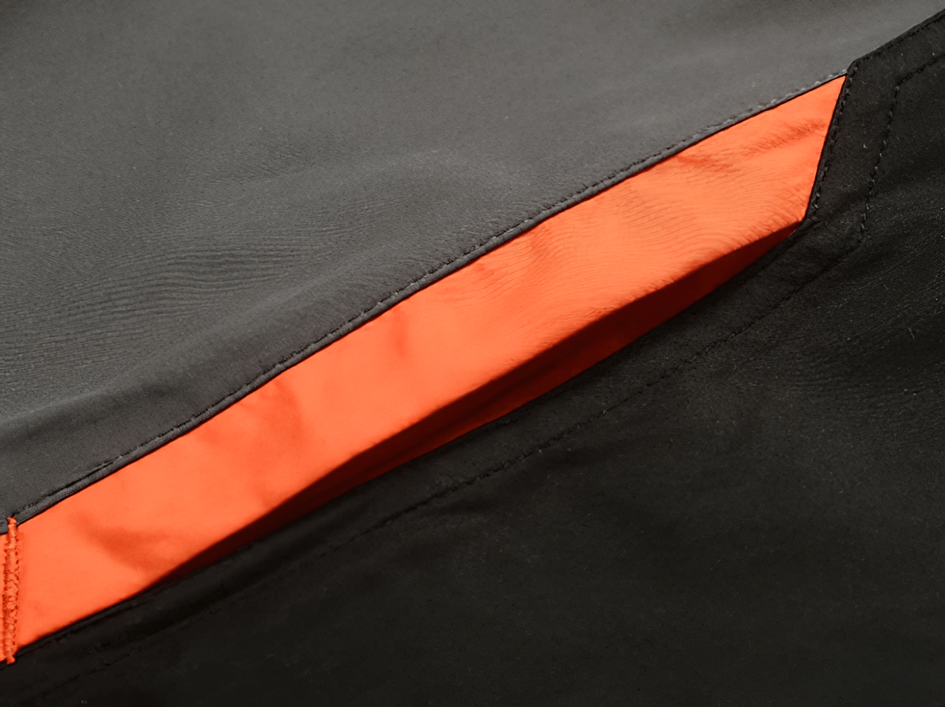 Close-up of a men's sports tracksuit zippered pocket with bold orange detail, perfect for casual training and sports activities.