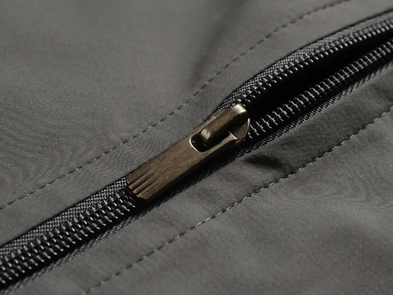 Close-up of a zipper on a men's polyester sports tracksuit jacket, highlighting sleek design and craftsmanship.