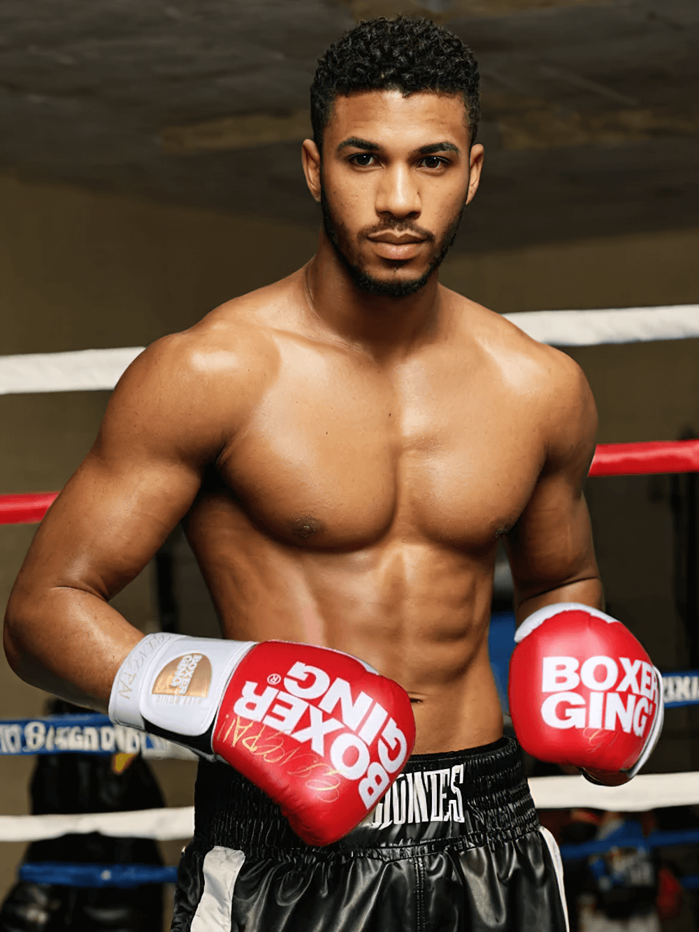 Boxer wearing red gloves in the ring, showcasing strength and readiness for training and sparring.