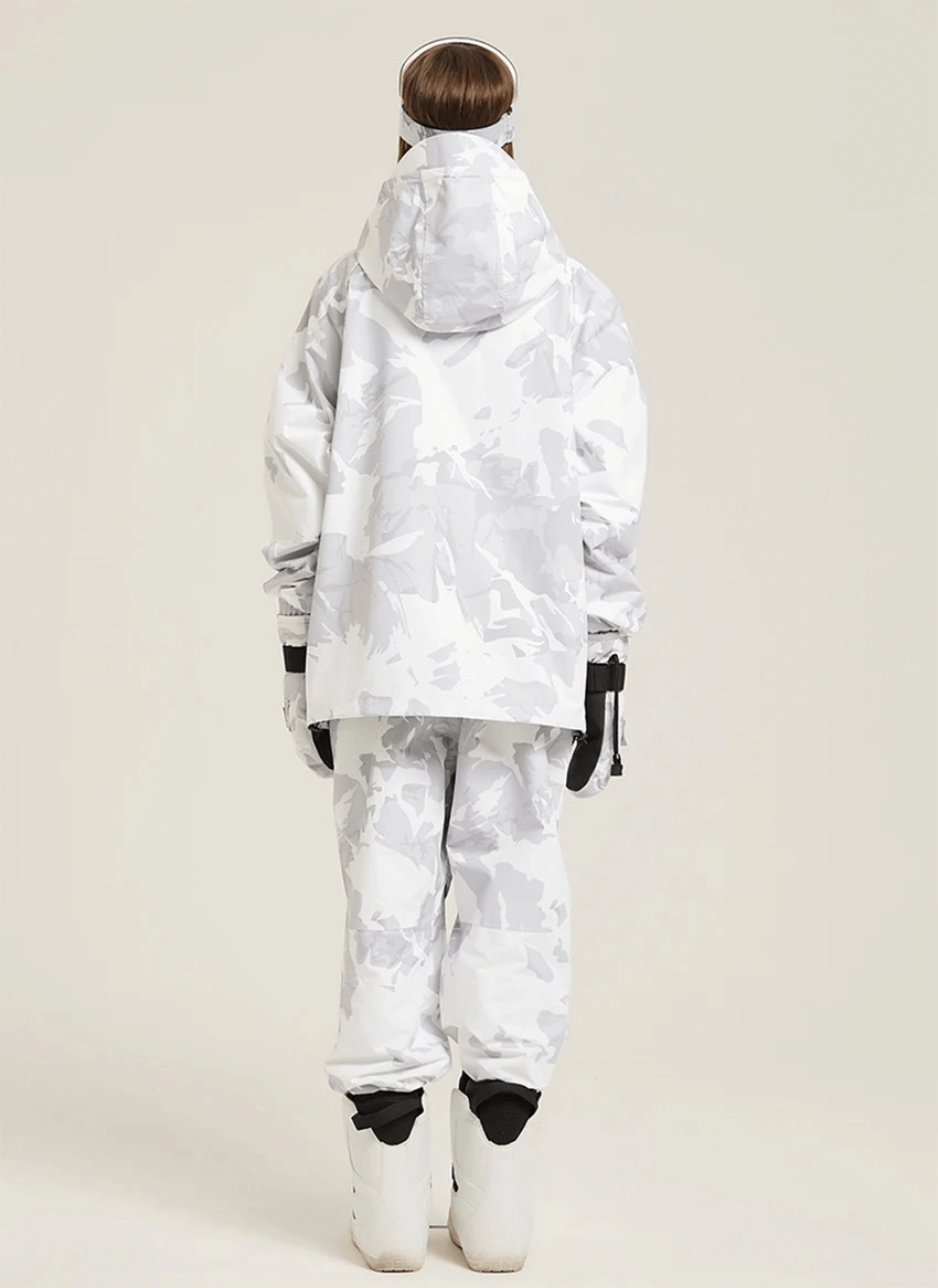 Woman in hooded white camouflage skiing jacket and pants, ready for winter adventure.