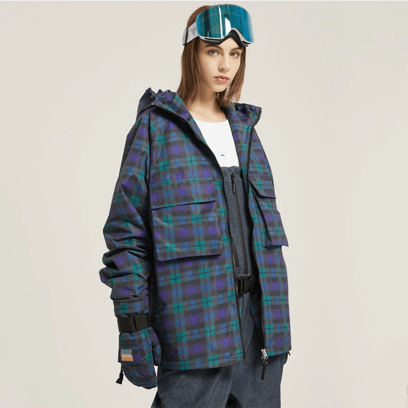 Woman modeling thick plaid skiing jacket with large pockets, two-way zip, hooded collar, and ski goggles, perfect for winter activities.
