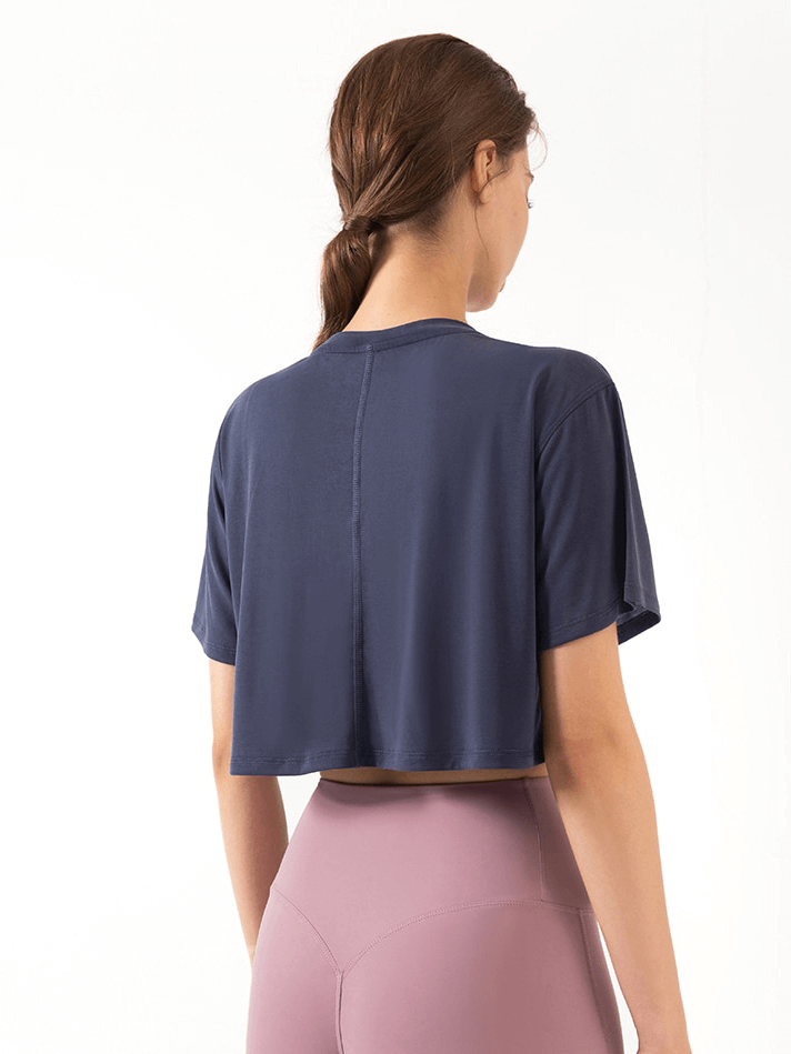 Woman wearing a navy blue ultralight short sleeve gym t-shirt, showcasing breathable and stretchy fabric.