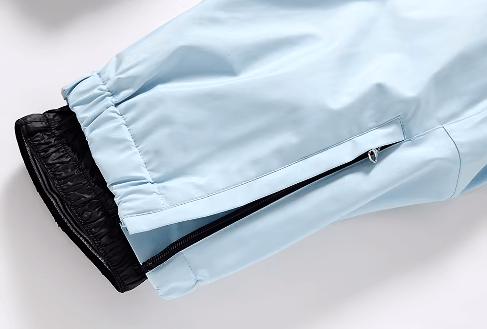 Light blue unisex breathable ski pants with zip pocket detail, showcasing durable waterproof polyester for skiing and snowboarding.