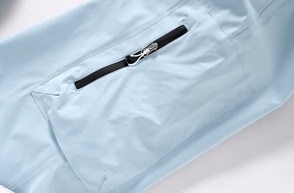 Close-up of light blue skiing pants with a black zippered pocket from the unisex breathable ski jacket and pants set.