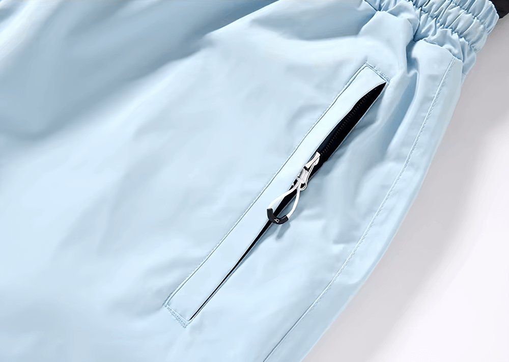 Close-up of light blue breathable ski pants with zip pocket, part of the unisex skiing jacket and pants set SF2564.