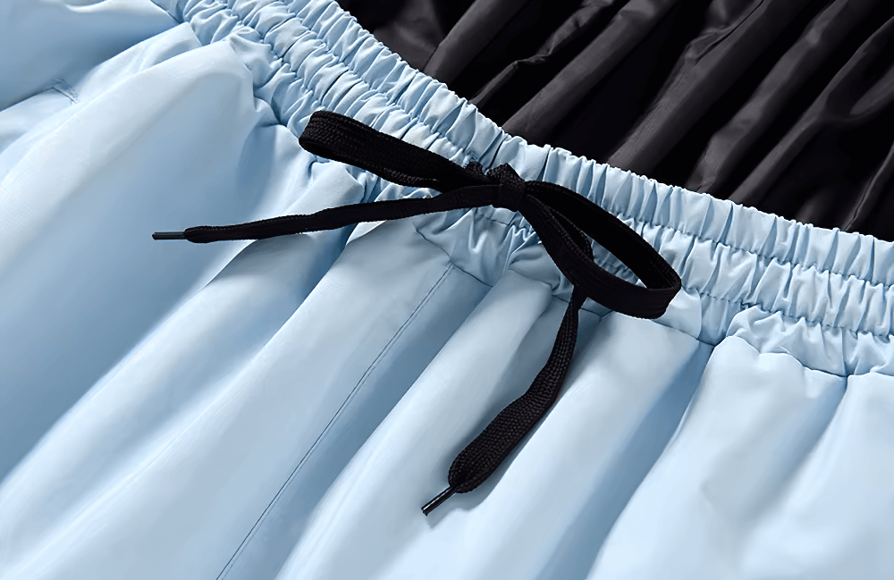 Close-up of unisex ski pants waist with black drawstring, showcasing breathable and windproof fabric. Ideal for skiing and snowboarding.