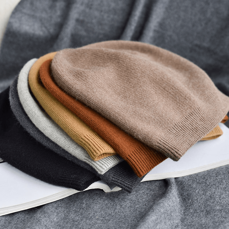Stack of unisex solid color cashmere wool beanies in various shades, perfect for winter warmth and casual style.