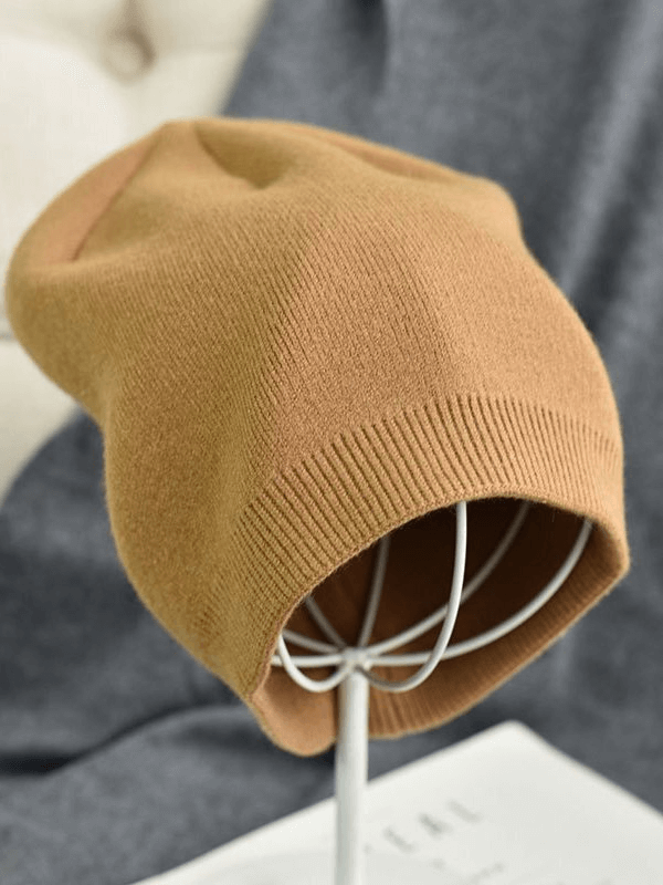 Unisex solid color cashmere beanie on display stand, perfect for warmth and style, made of 100% wool in a cozy casual design.