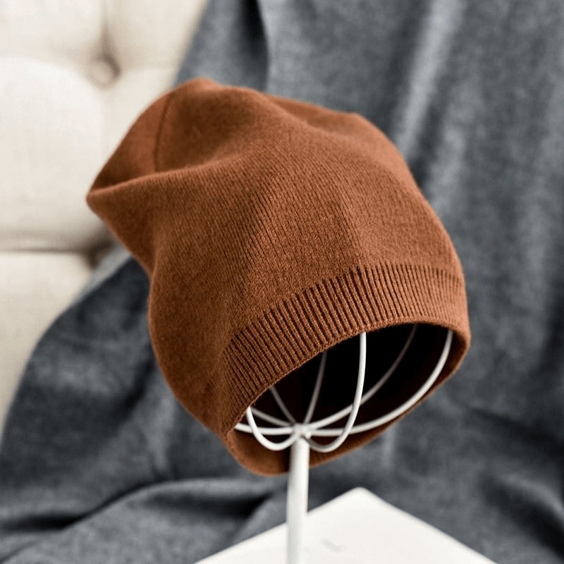 Cozy brown cashmere beanie on display, ideal unisex winter headwear for warmth and style, crafted from 100% wool with a solid pattern.