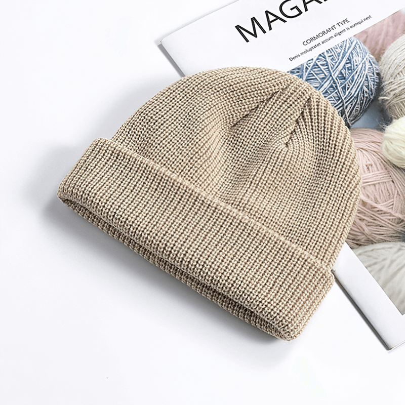 Beige cotton unisex brimless knitted hat on magazine, ideal for keeping warm during outdoor activities.