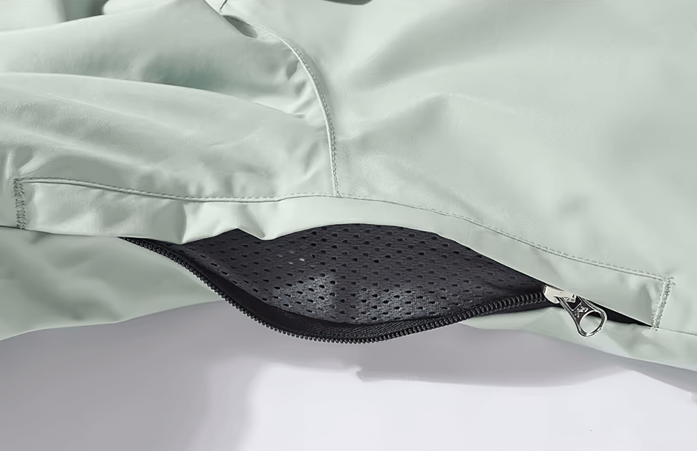 Close-up of grey unisex waterproof ski jacket with breathable mesh lining and zipper detail for skiing and snowboarding.