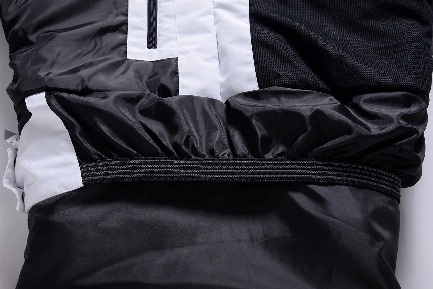 Close-up of unisex waterproof ski suit SF2257, showcasing durable black and white fabric with elastic waistband.