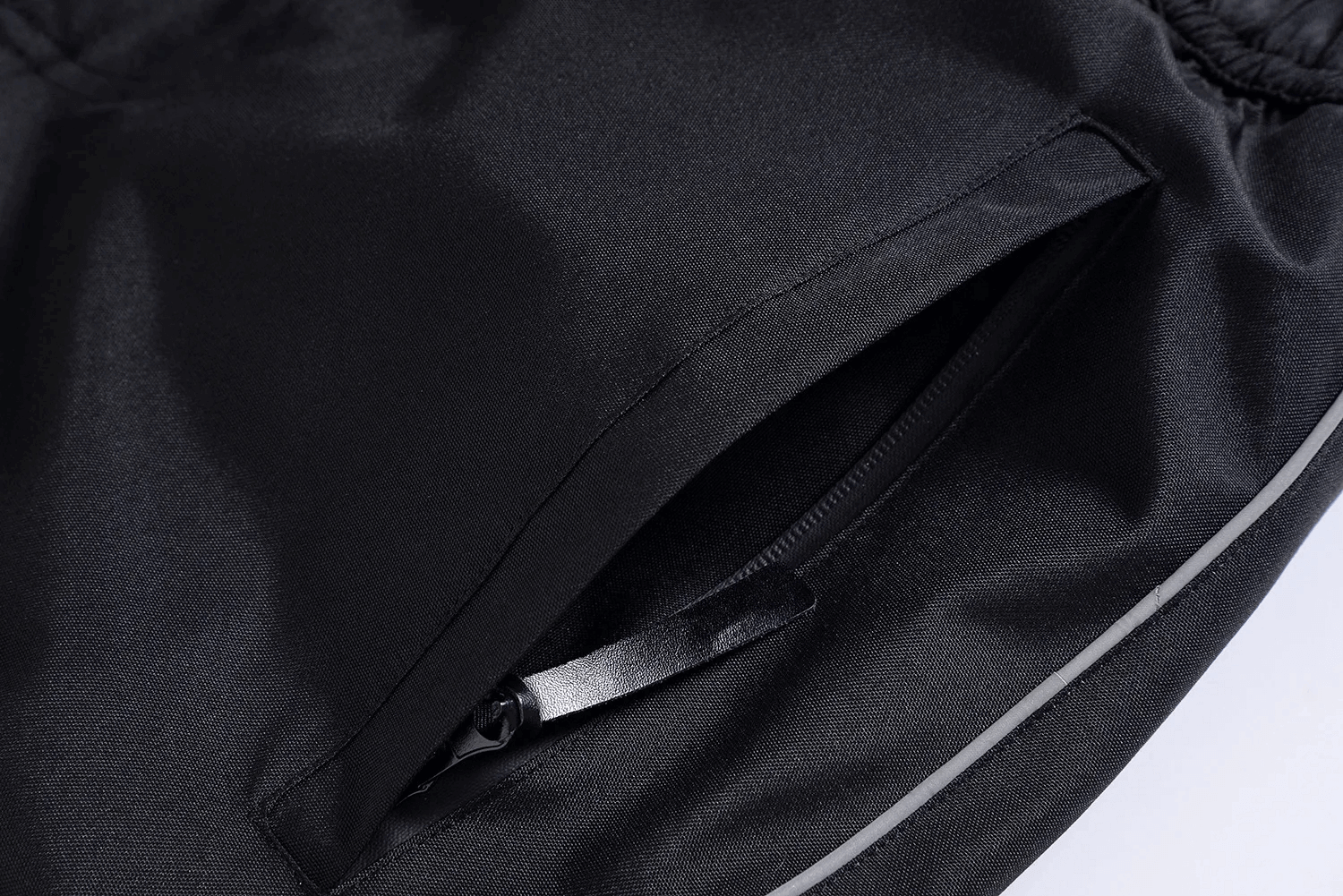 Close-up of unisex waterproof ski suit pocket with zipper, showcasing durable polyester fabric in black. Ideal for winter sports gear.