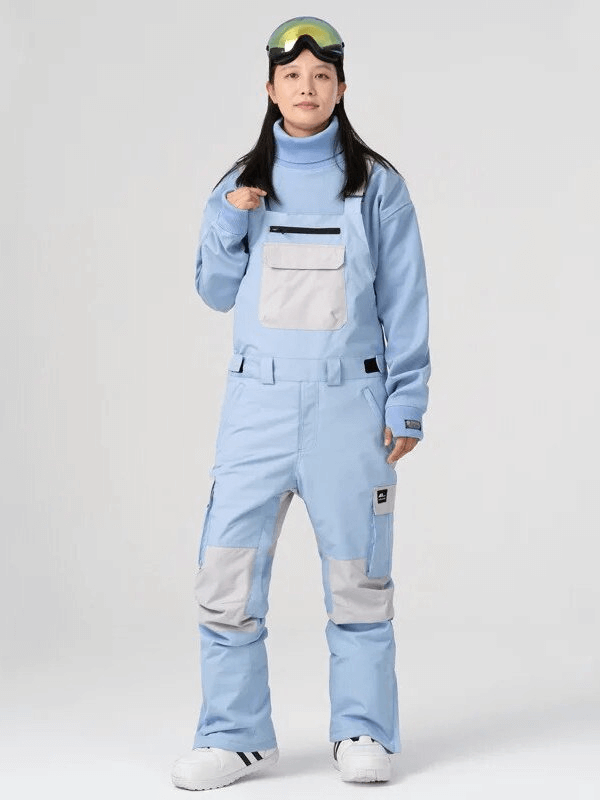 Person wearing light blue unisex windproof waterproof ski pants with straps, perfect for skiing adventures.