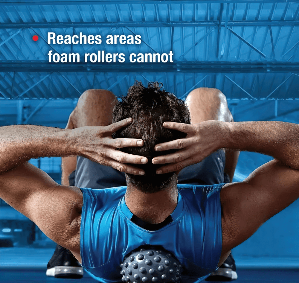 Man using vibrating massage ball for upper back relief in gym, targeting areas foam rollers can't reach.