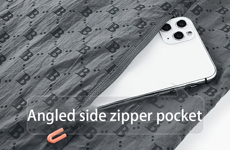 Close-up of a jacket's angled side zipper pocket with letter B print, showing a phone inside the pocket.