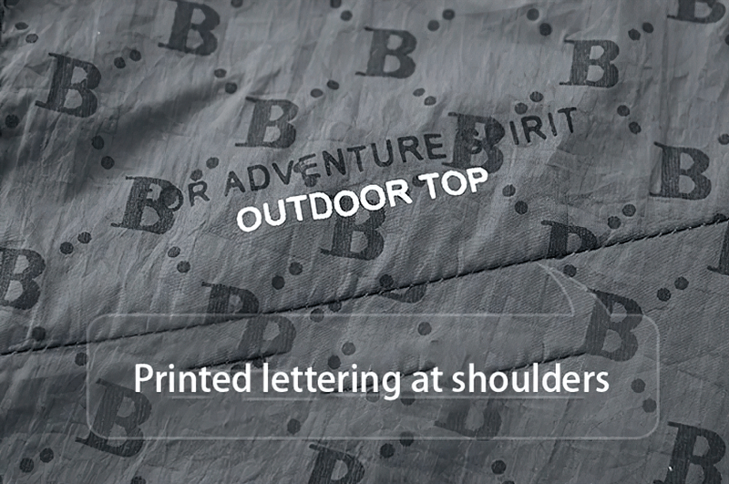 Close-up of UV sun protection jacket with letter B print and 'Adventure Spirit Outdoor Top' text on fabric.