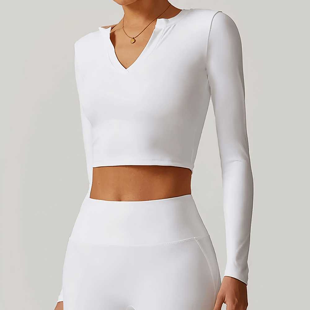 Woman wearing a white V-neck long sleeve yoga crop top, perfect for running and fitness, featuring breathable and quick-dry fabric.