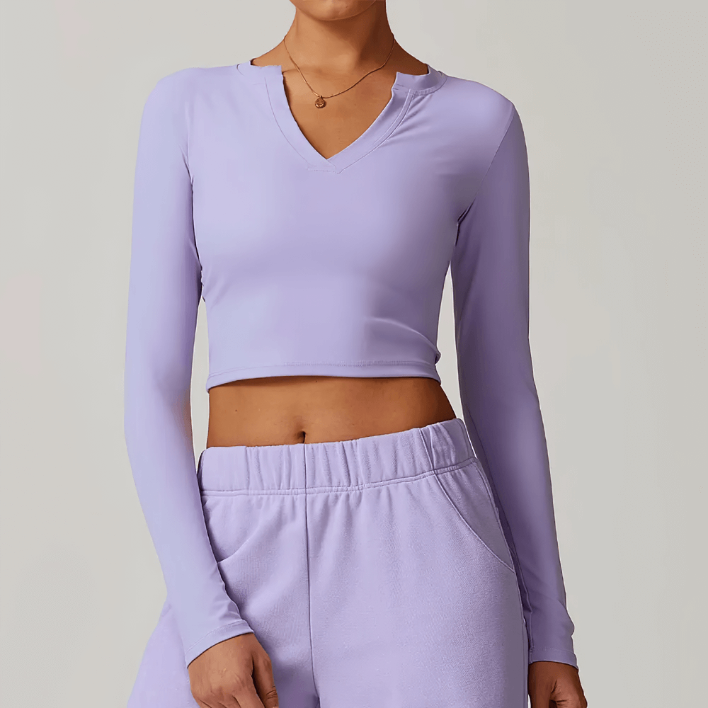 Woman wearing a purple V-Neck long sleeve crop top with breathable, quick-dry fabric ideal for yoga and running fitness.