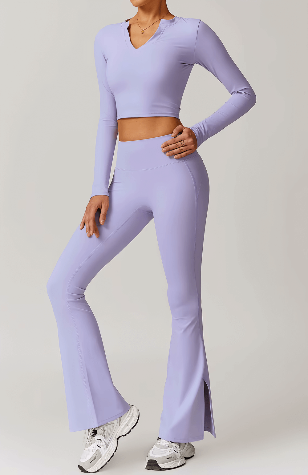 Woman wearing a purple V-Neck Yoga Long Sleeve Crop Top with flare yoga pants.