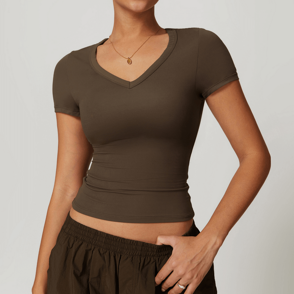 Woman wearing a stylish V-neck yoga T-shirt, perfect for fitness enthusiasts. Features breathable, quick-drying fabric and short sleeves.