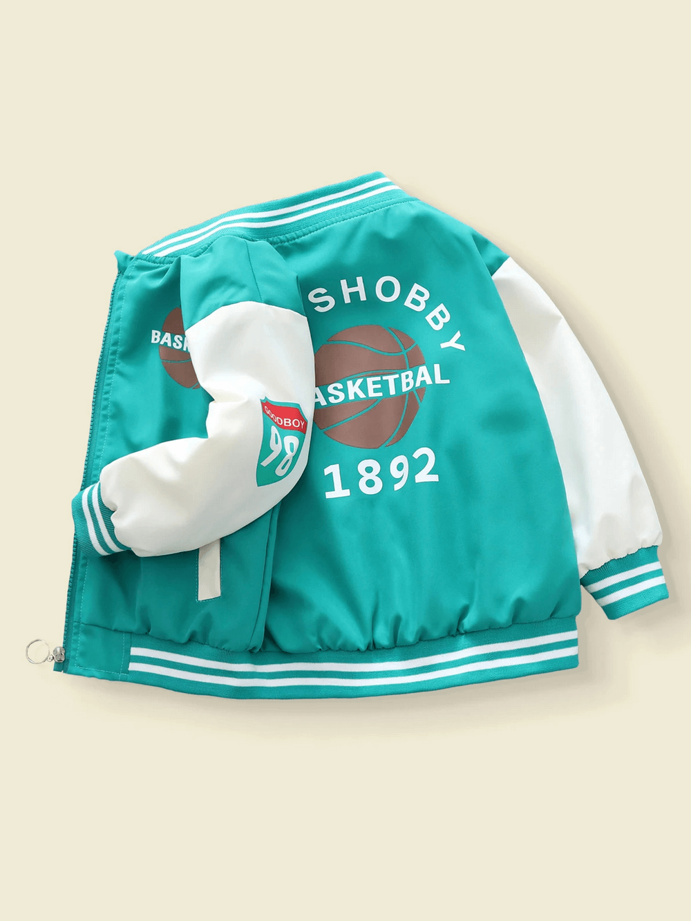 Varsity style basketball jacket for kids in teal and white with sports graphics, ideal for young athletes. Zip-up, ribbed cuffs.