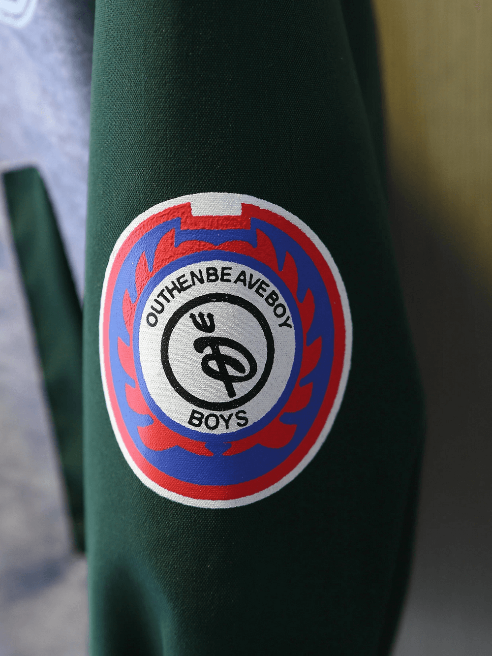 Close-up of varsity jacket sleeve with colorful badge featuring a sporty design and bold text.