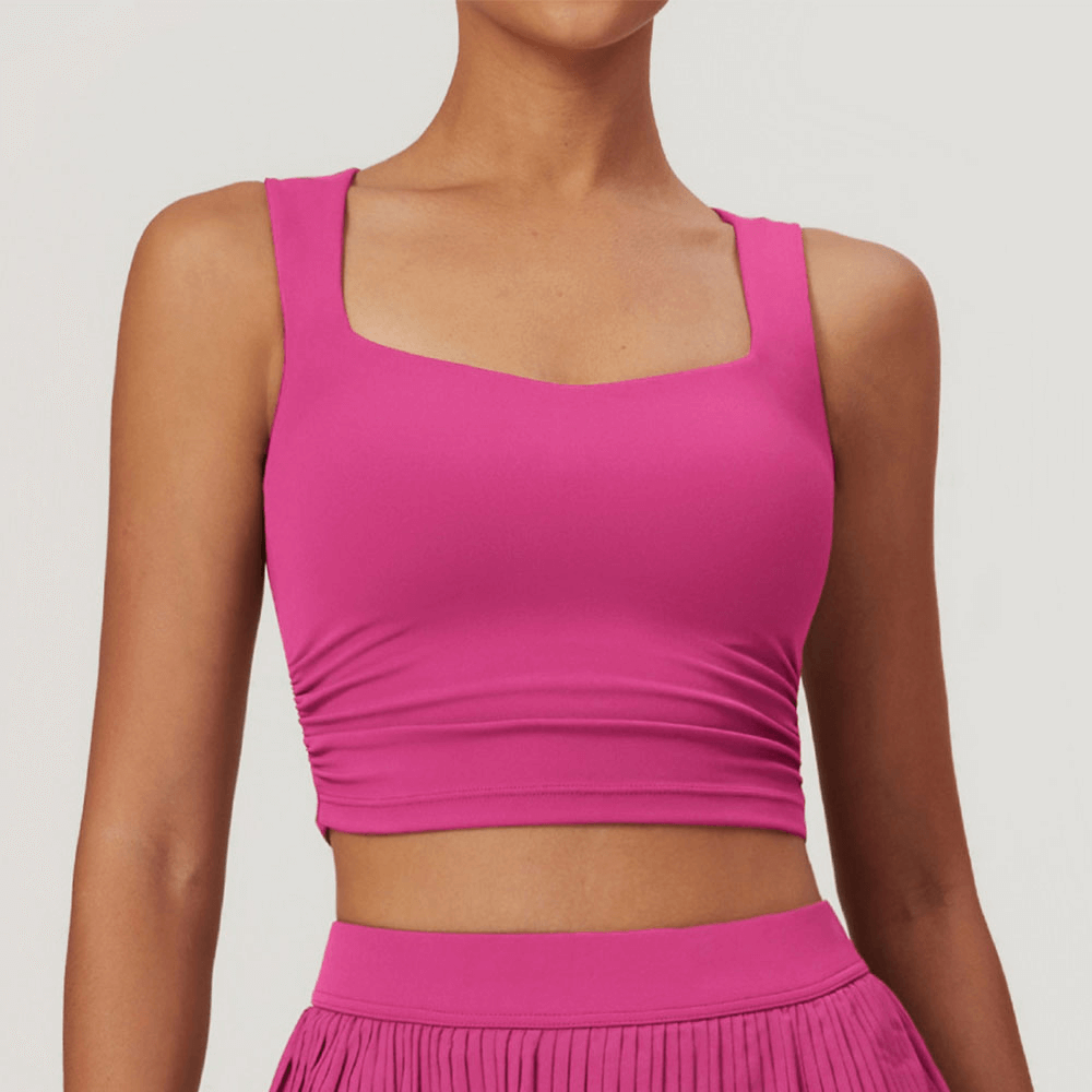 Versatile pink workout crop tank for active women, perfect for running, cycling, and dancing. Made of flexible nylon and spandex.