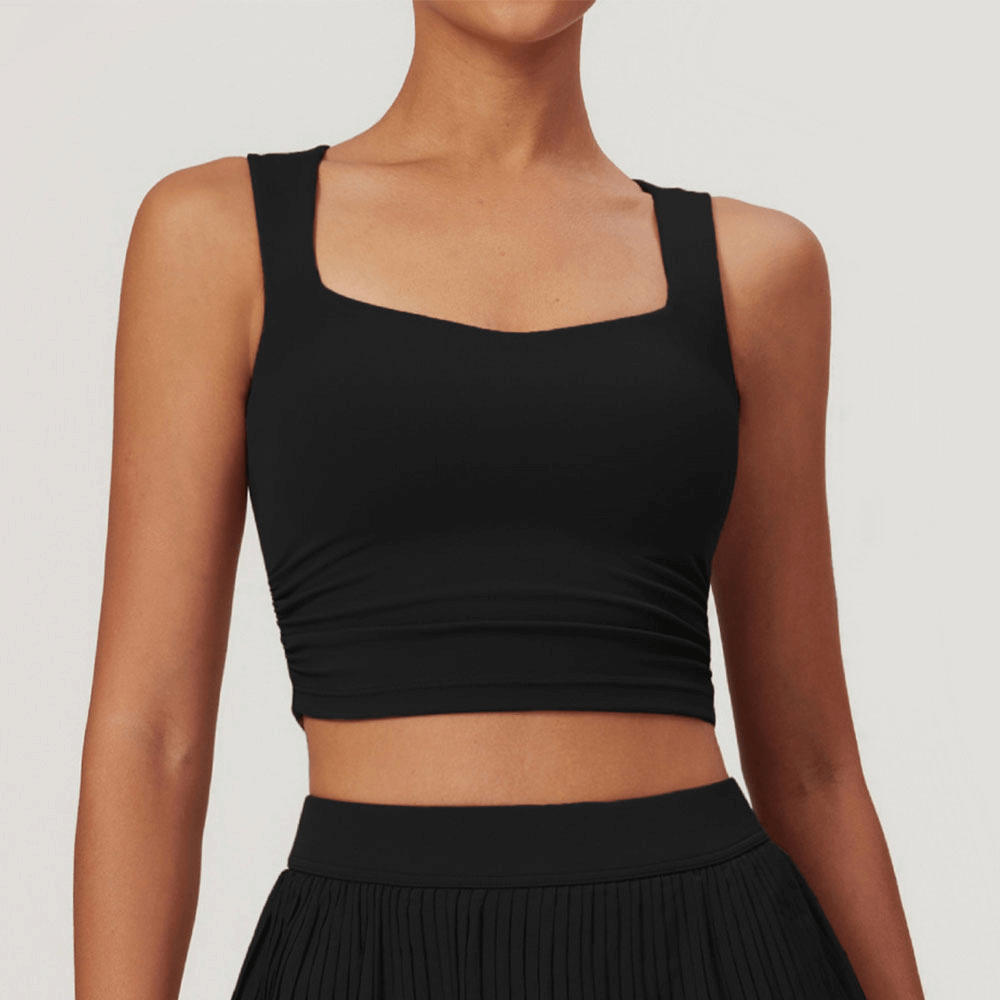 Woman wearing a sleek black versatile workout crop tank top for fitness, made from nylon and spandex for breathability and flexibility.