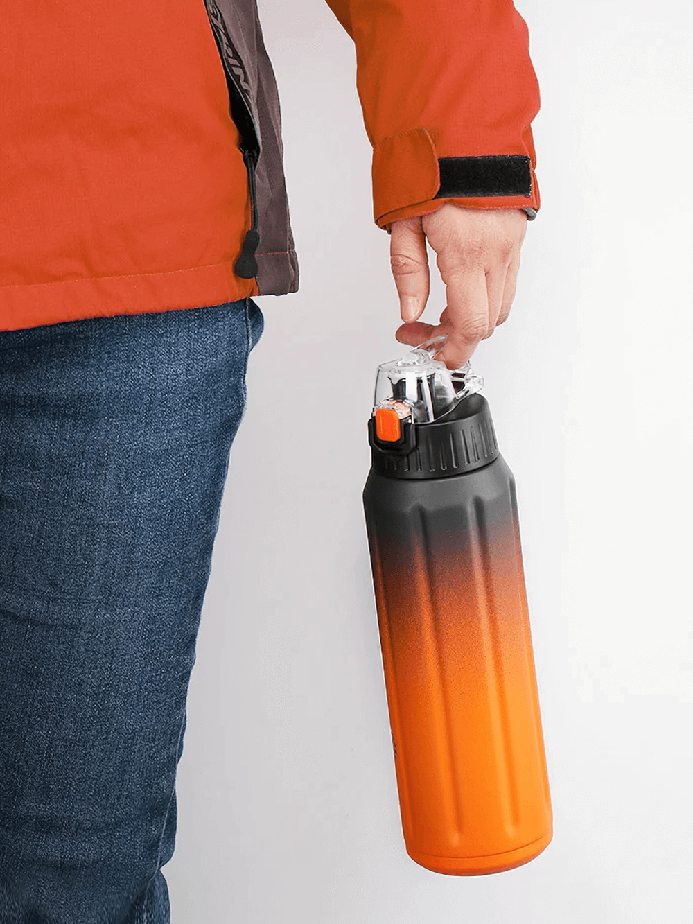 Person holding orange 600ml insulated flask, perfect for athletes. Durable stainless steel, leak-proof design for active lifestyles.