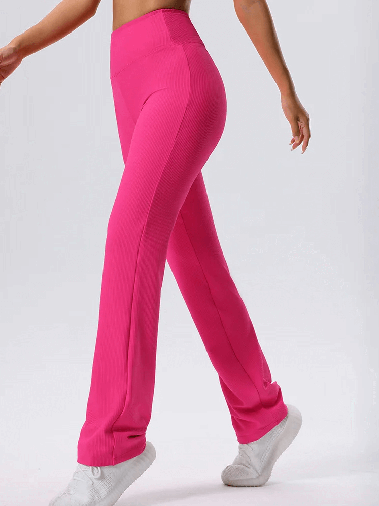Woman wearing vibrant pink ribbed yoga leggings for stretch and comfort, perfect for flexibility and movement. Elastic waist for a snug fit.