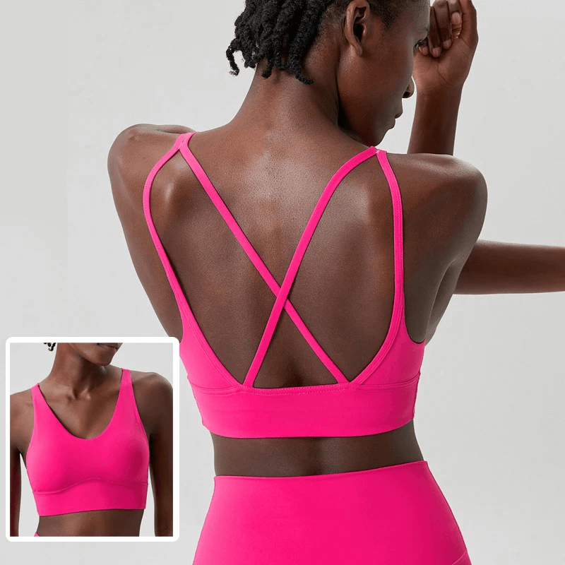 Bold pink sports bra with crisscross straps for optimal support during workouts. Vibrant color and breathable fabric for active wear.