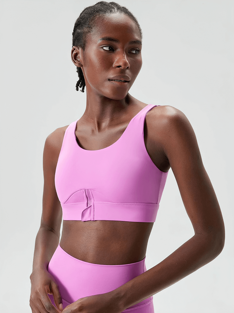 Woman wearing vibrant pink yoga fitness bra, showcasing breathable sportswear with anti-friction weave for high-impact workouts.