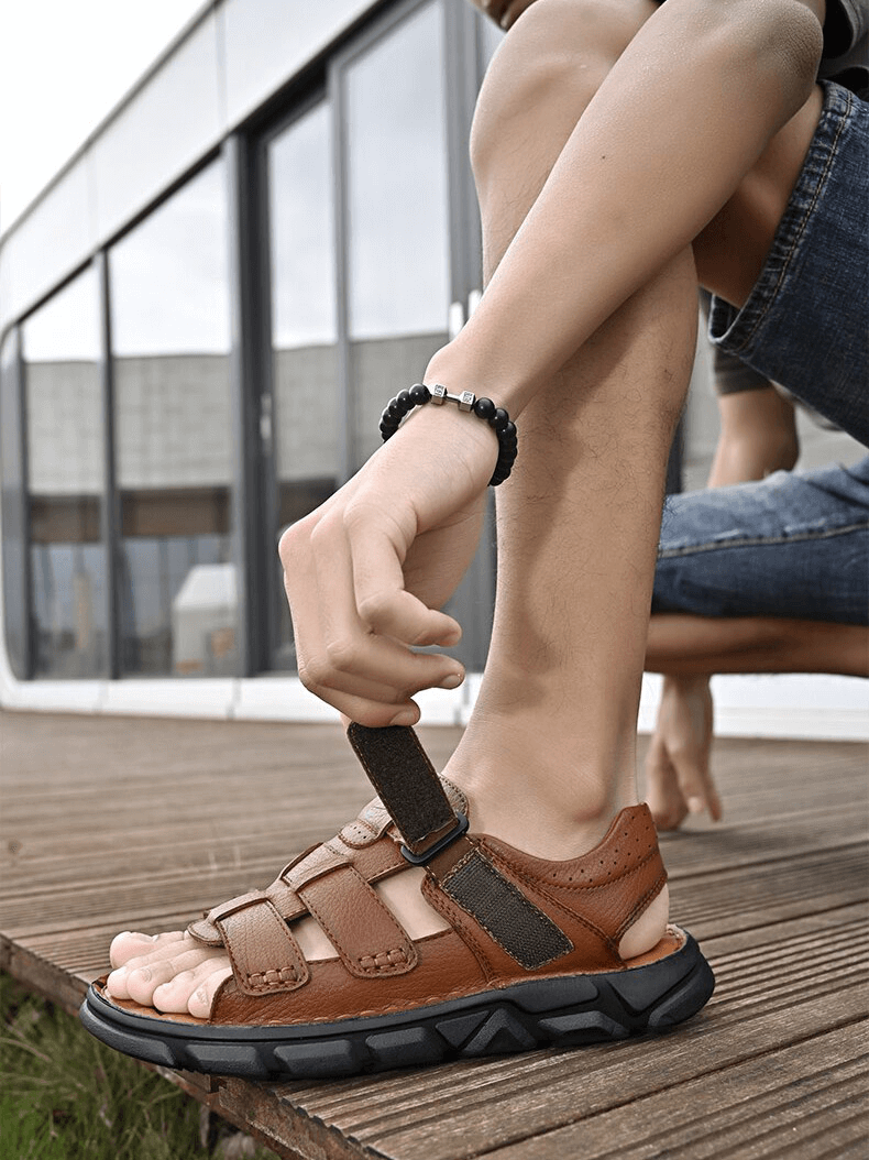 Man wearing vintage men's sandals with soft bottom on wooden deck, showcasing outdoor trekking footwear style SF1340.