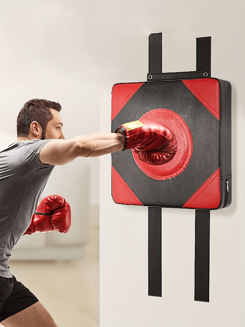 Boxer punching wall-mounted SF2723 boxing pad with red gloves, featuring durable PU leather and Oxford fabric, ideal for intense workouts.