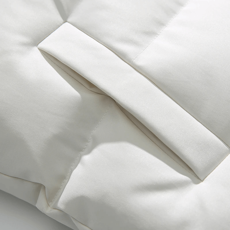 Close-up of white puffer jacket with elegant patchwork detailing and broadcloth fabric, showcasing winter style and warmth.