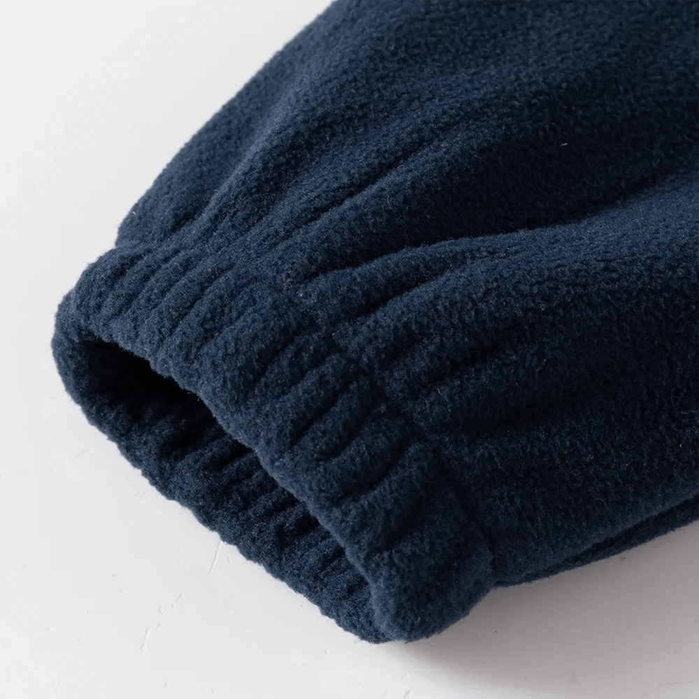 Close-up of navy fleece jacket sleeve, showcasing cozy fabric and colorblock design for kids' cold weather wear.