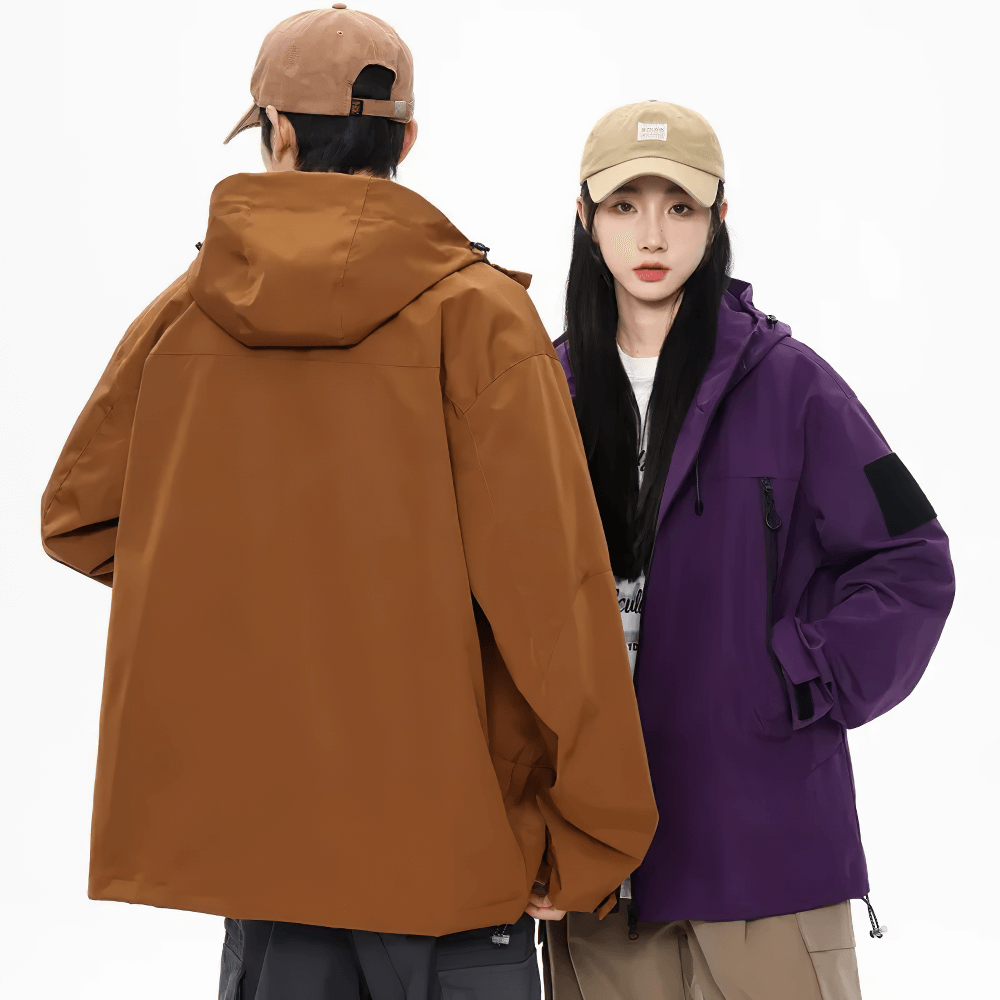 Two people wearing a waterproof hiking jacket with hood, in brown and purple, perfect for outdoor activities.