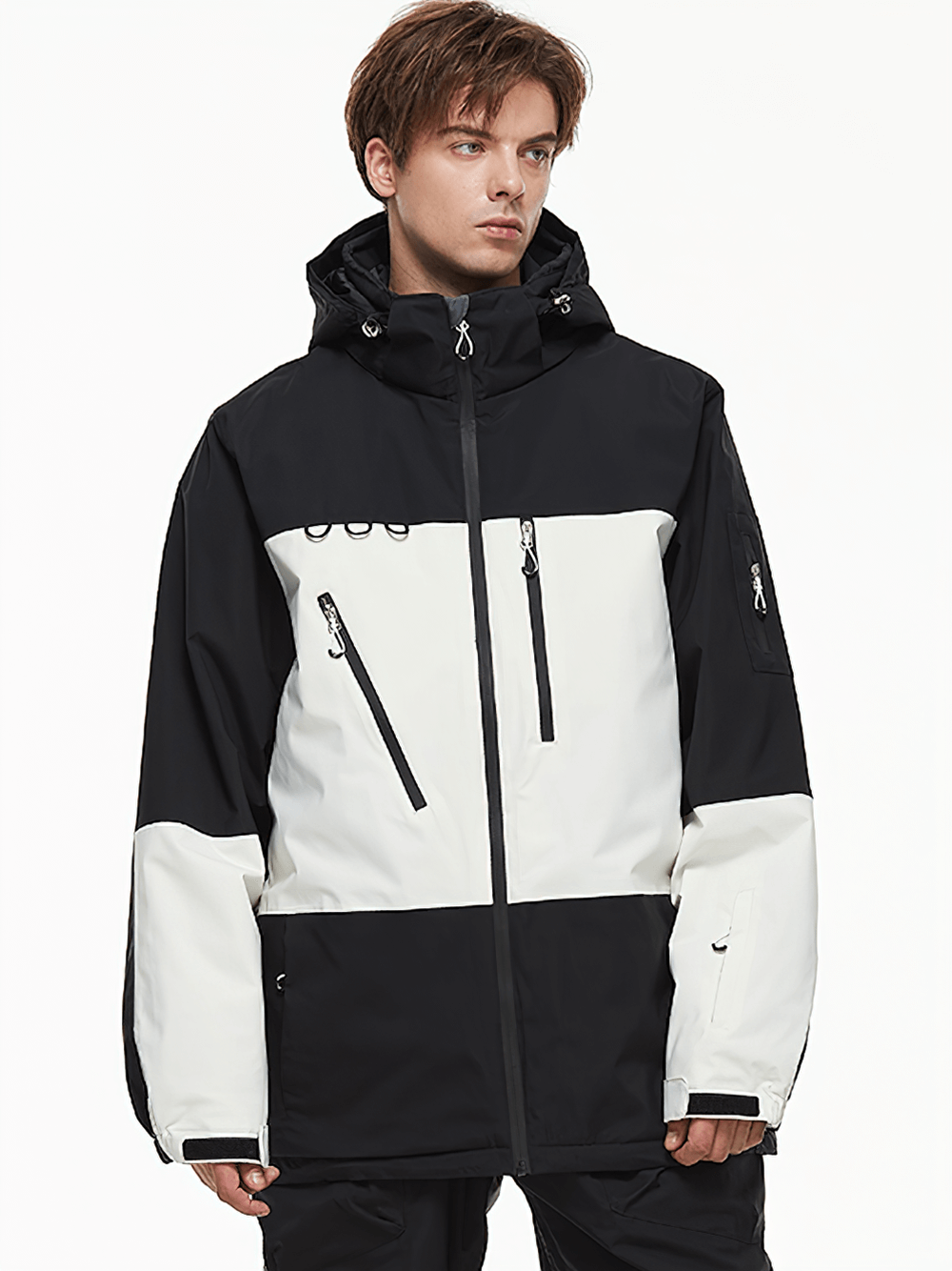 Man wearing black and white waterproof hooded ski jacket, insulated for skiing, snowboarding, and winter sports.