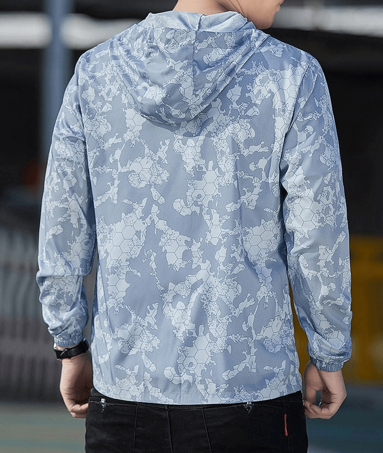 Man wearing a blue-patterned waterproof lightweight windbreaker with a hood, viewed from the back, ideal for outdoor activities.