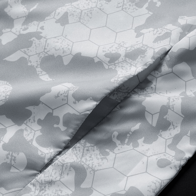 Close-up of grey and white patterned fabric from a waterproof windbreaker with honeycomb and abstract designs, perfect for outdoor use.