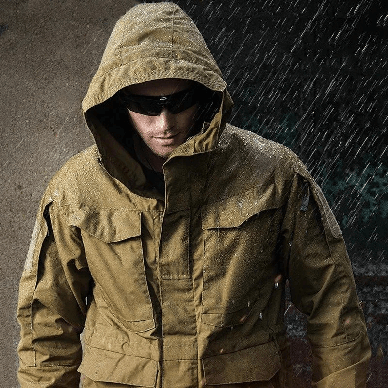 Man wearing waterproof men's windbreaker with hood and pockets, ideal for outdoor activities like hiking and camping in rainy weather.