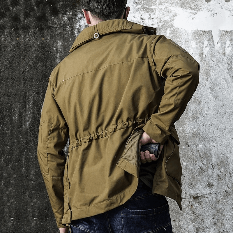 Man wearing a waterproof brown windbreaker with hood and pockets, ideal for biking, camping, and hiking outdoors.