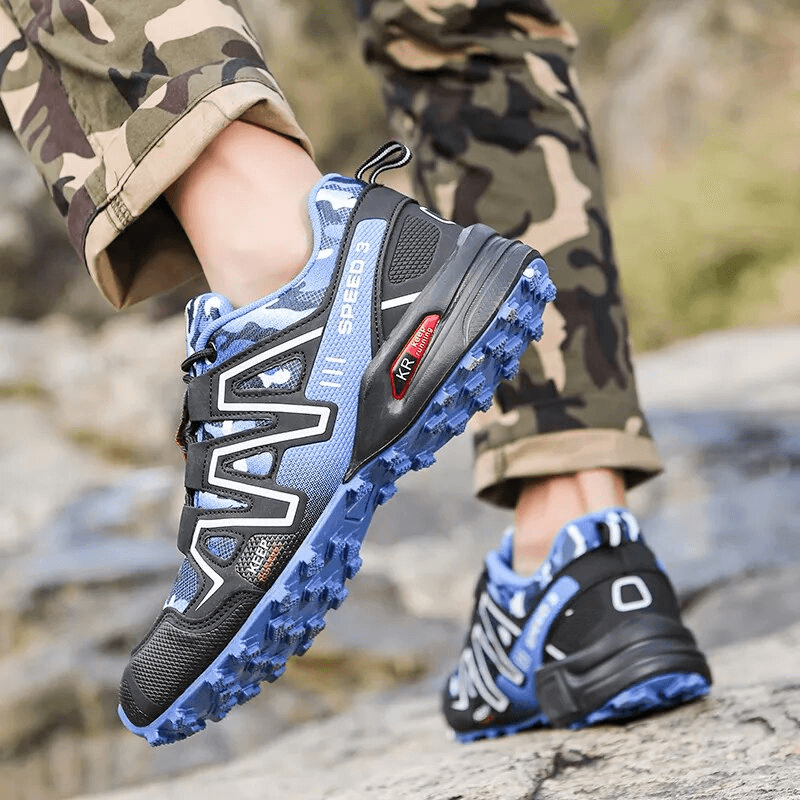 Men's blue and black hiking shoes with non-slip sole, perfect for outdoor adventures, shown on rocky terrain. Model SF1633.