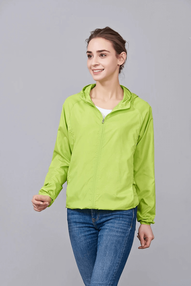 Woman wearing waterproof polyester hiking jacket, SF2005, in green. Lightweight, sun-protective, perfect for camping and outdoor activities.