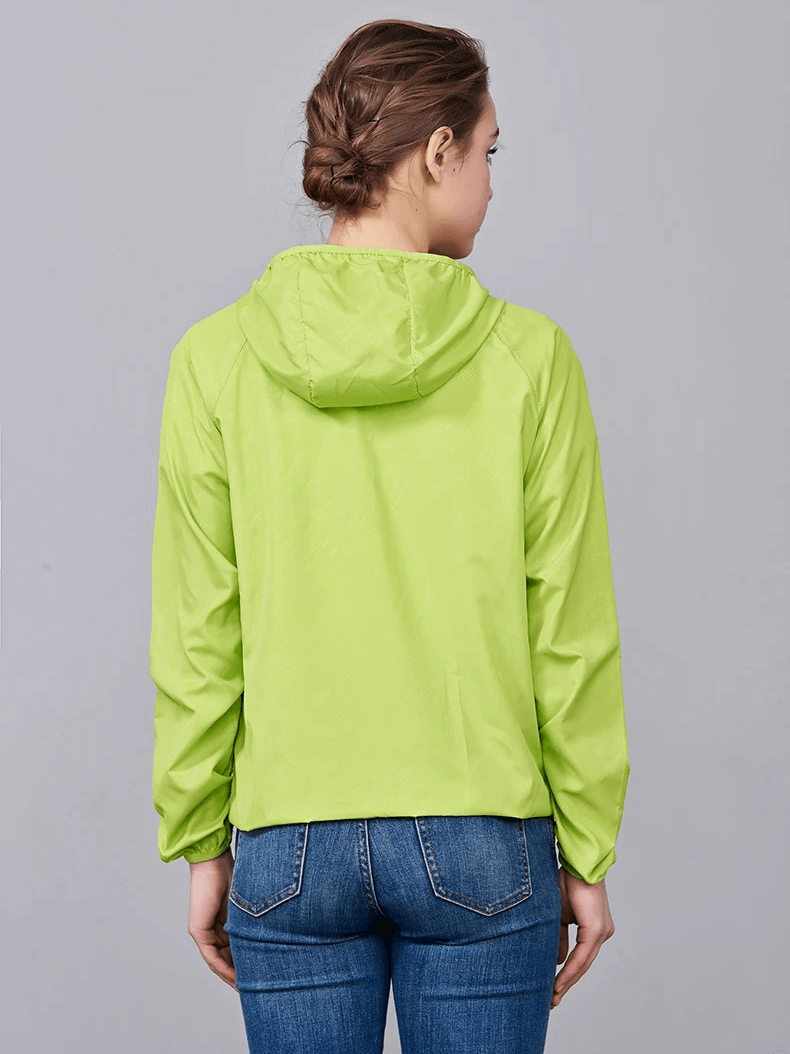 Back view of a woman wearing a green waterproof polyester hiking jacket, showcasing its sun-protective and breathable features.